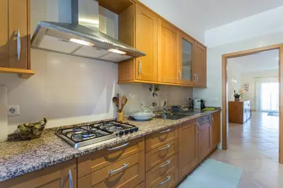 a kitchen with wooden cabinets and a stove top oven at vista golf in Quarteira