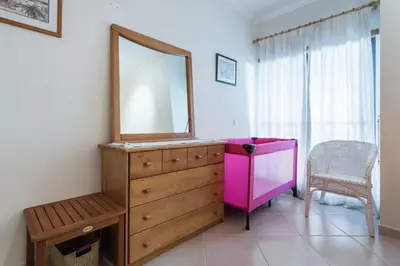 a bathroom with a dresser with a mirror and a chair at vista golf in Quarteira