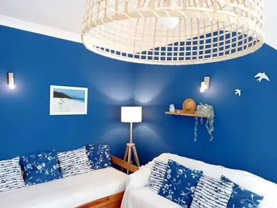 a blue room with a couch and a chandelier at Casa de Praia dos Avós in Quarteira