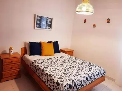 a bedroom with a bed with a black and white comforter at Casa de Praia dos Avós in Quarteira
