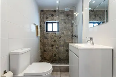 a white bathroom with a toilet and a sink at Blife Lucelya private rooms at Faro beach in Faro