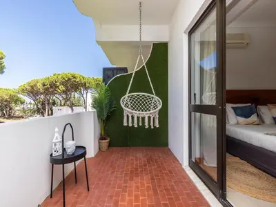 a balcony with a swing and a bed at Akisol Vilamoura Iron in Quarteira