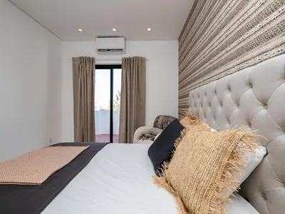 a bedroom with a large bed and a chair at Akisol Vilamoura Iron in Quarteira