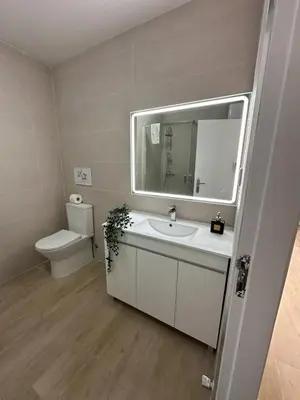 a bathroom with a sink and a toilet and a mirror at Quarteira Atlantic View in Sesmarias