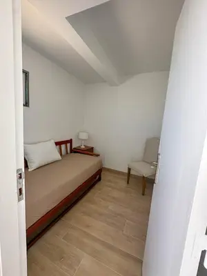 a small bedroom with a bed and a chair at Quarteira Atlantic View in Sesmarias