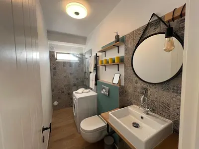 a bathroom with a sink and a toilet and a mirror at casa do cesar in Albufeira