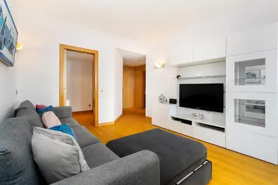 a living room with a gray couch and a tv at Marina Family Apartment - Pool & Garage in Vilamoura