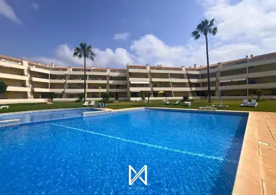 a swimming pool in front of a large building at MyStay - Farol Moura in Quarteira
