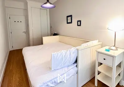 a small bedroom with a white bed and a night stand at MyStay - Farol Moura in Quarteira
