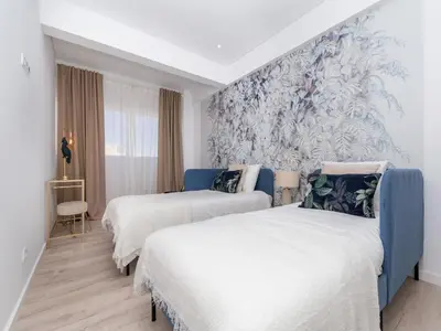 two beds in a room with a mural on the wall at Akisol Faro Virtuous in Faro