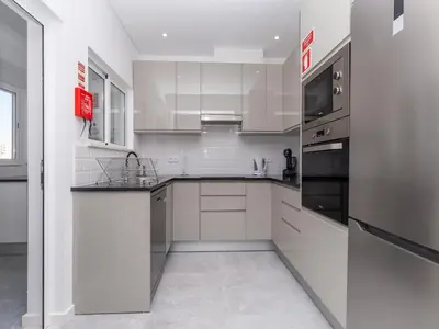a white kitchen with white cabinets and appliances at Akisol Faro Virtuous in Faro