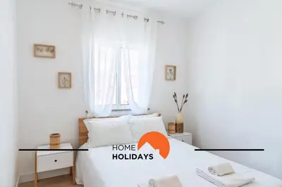 a bedroom with a bed with a home holidays sign on it at #313 Travessa dos Arcos Flat by Home Holidays in Albufeira