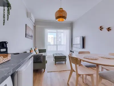 a kitchen and living room with a table and chairs at Apartamento Vida Pura com 2 quartos e vista mar in Quarteira
