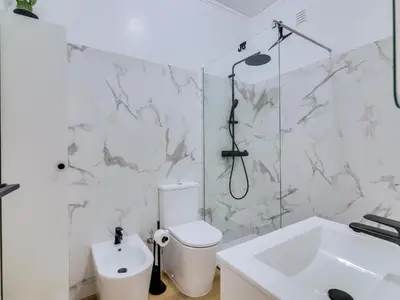 a white bathroom with a toilet and a sink at Apartamento Vida Pura com 2 quartos e vista mar in Quarteira