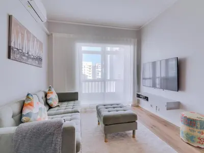 a living room with a couch and a tv at Apartamento Vida Pura com 2 quartos e vista mar in Quarteira