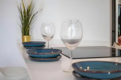 two wine glasses sitting on a table with plates and bowls at Talia Lux - two-bedroom luxury apartment by HD in Vilamoura