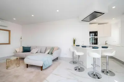 a white living room with a couch and a kitchen at Talia Lux - two-bedroom luxury apartment by HD in Vilamoura