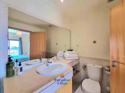 a bathroom with a sink and a toilet and a mirror at Two Bedroom Apartment with Sea Views in Albufeira in Albufeira