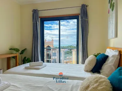a bedroom with a bed with a large window at Two Bedroom Apartment with Sea Views in Albufeira in Albufeira