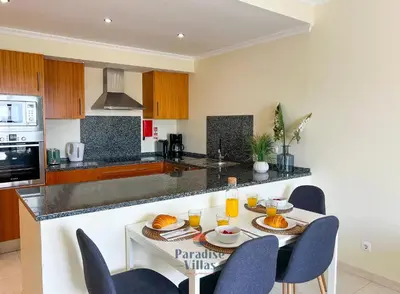 a kitchen with a table and chairs in a kitchen at Two Bedroom Apartment with Sea Views in Albufeira in Albufeira