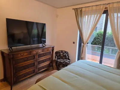 a bedroom with a television on a dresser and a window at Casa dos sonhos em Vale do Lobo in Loulé