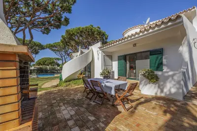 a house with a swimming pool and blue lounge chairs at Joliet in Vilamoura