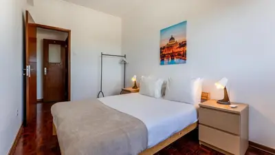 a bedroom with a white bed and a picture on the wall at Cosy 3Bdr Flat near University by LovelyStay in Faro