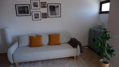 a living room with a gray couch with orange pillows at Pipos d'Al-buhera in Albufeira