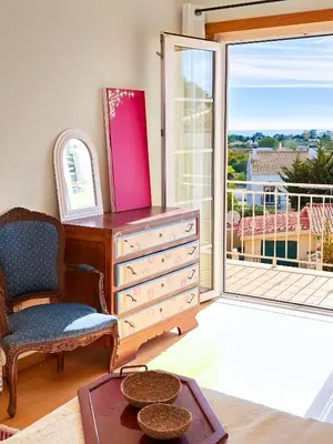 a dresser and a chair in a room with a balcony at Balaia Maggs House Pool & Ocean view by BeCherish in Albufeira