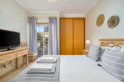 a bedroom with a bed with a television and a desk at Peaceful 2Bdr with Pool in Vilamoura by LovelyStay in Quarteira