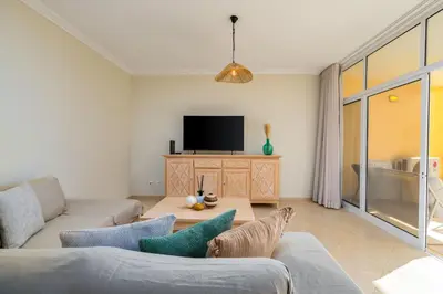 a living room with a couch and a tv at Peaceful 2Bdr with Pool in Vilamoura by LovelyStay in Quarteira