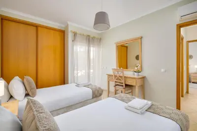 a bedroom with two beds and a desk and a mirror at Peaceful 2Bdr with Pool in Vilamoura by LovelyStay in Quarteira