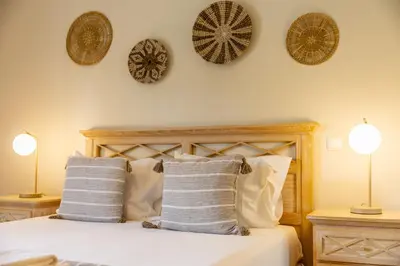a bedroom with a bed with three plates on the wall at Peaceful 2Bdr with Pool in Vilamoura by LovelyStay in Quarteira