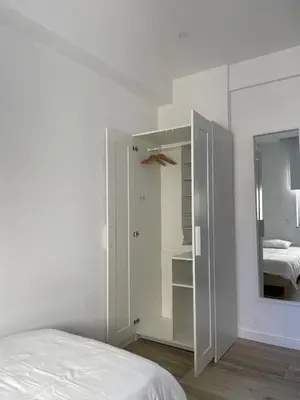 a white bedroom with a bed and a mirror at O&P Apartments in Faro