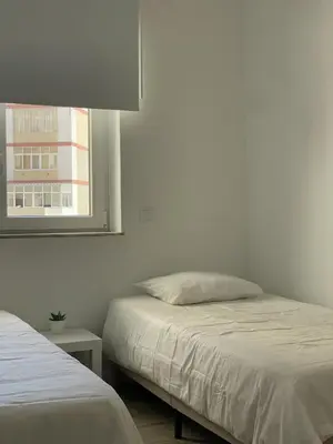 a bedroom with two beds and a window at O&P Apartments in Faro