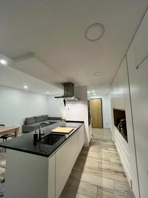 a kitchen with a sink and a living room at O&P Apartments in Faro
