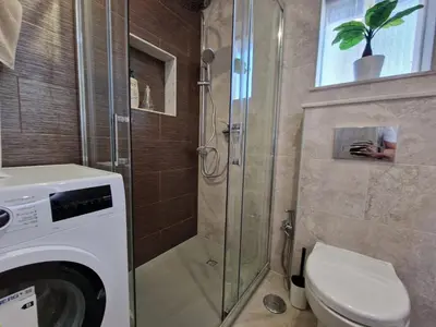 a bathroom with a shower and a washing machine at O&P Apartments in Faro