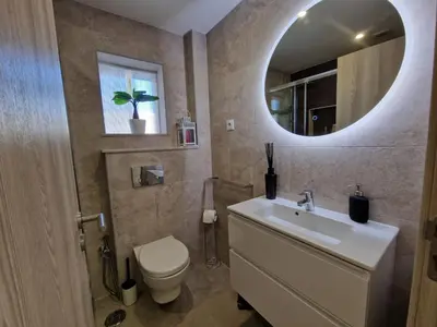 a bathroom with a sink and a toilet and a mirror at O&P Apartments in Faro