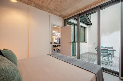 a bedroom with a bed and sliding glass doors at The Warehouse - Industrial Loft in Faro