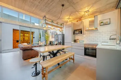 a kitchen with a wooden table and a couch at The Warehouse - Industrial Loft in Faro