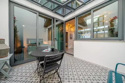 a dining room with a table and large windows at The Warehouse - Industrial Loft in Faro