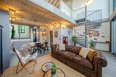 a living room with a brown couch and a table at The Warehouse - Industrial Loft in Faro