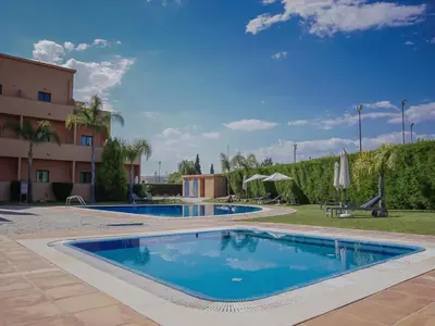 a swimming pool in a resort with a building at Akivillas Quarteira Cool in Quarteira