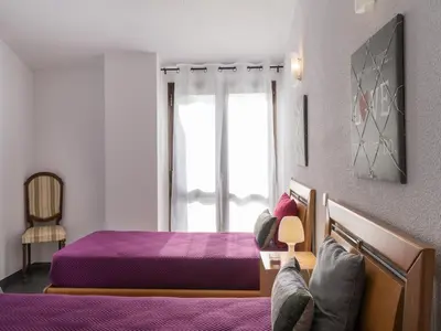 a bedroom with a purple bed and a window at Akivillas Quarteira Cool in Quarteira
