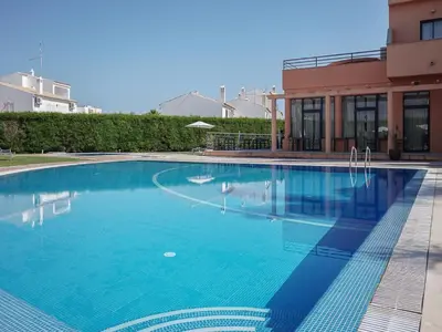 a swimming pool in front of a building at Akivillas Quarteira Cool in Quarteira