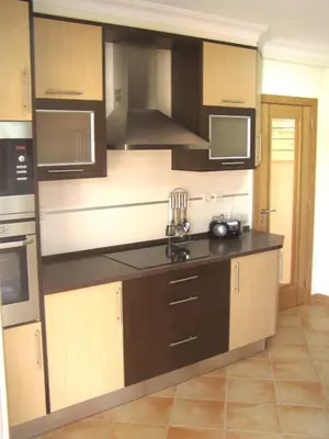 a kitchen with wooden cabinets and stainless steel appliances at ABF38, encantadora Villa V4 em lugar sossegado in Guia