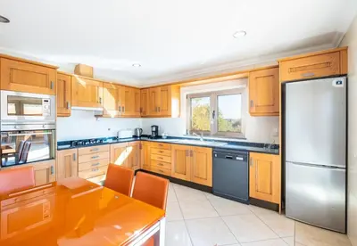 a kitchen with wooden cabinets and a stainless steel refrigerator at Villa Sierra in Guia