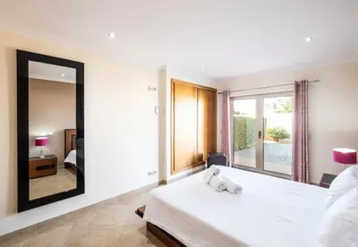 a bedroom with a large white bed with a mirror at Villa Sierra in Guia