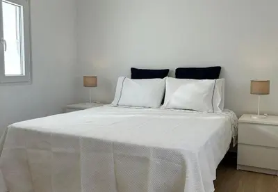 a bedroom with a white bed with two night stands at Playa Vista guest house in Albufeira