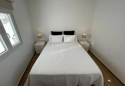 a bedroom with a white bed with two night stands at Playa Vista guest house in Albufeira